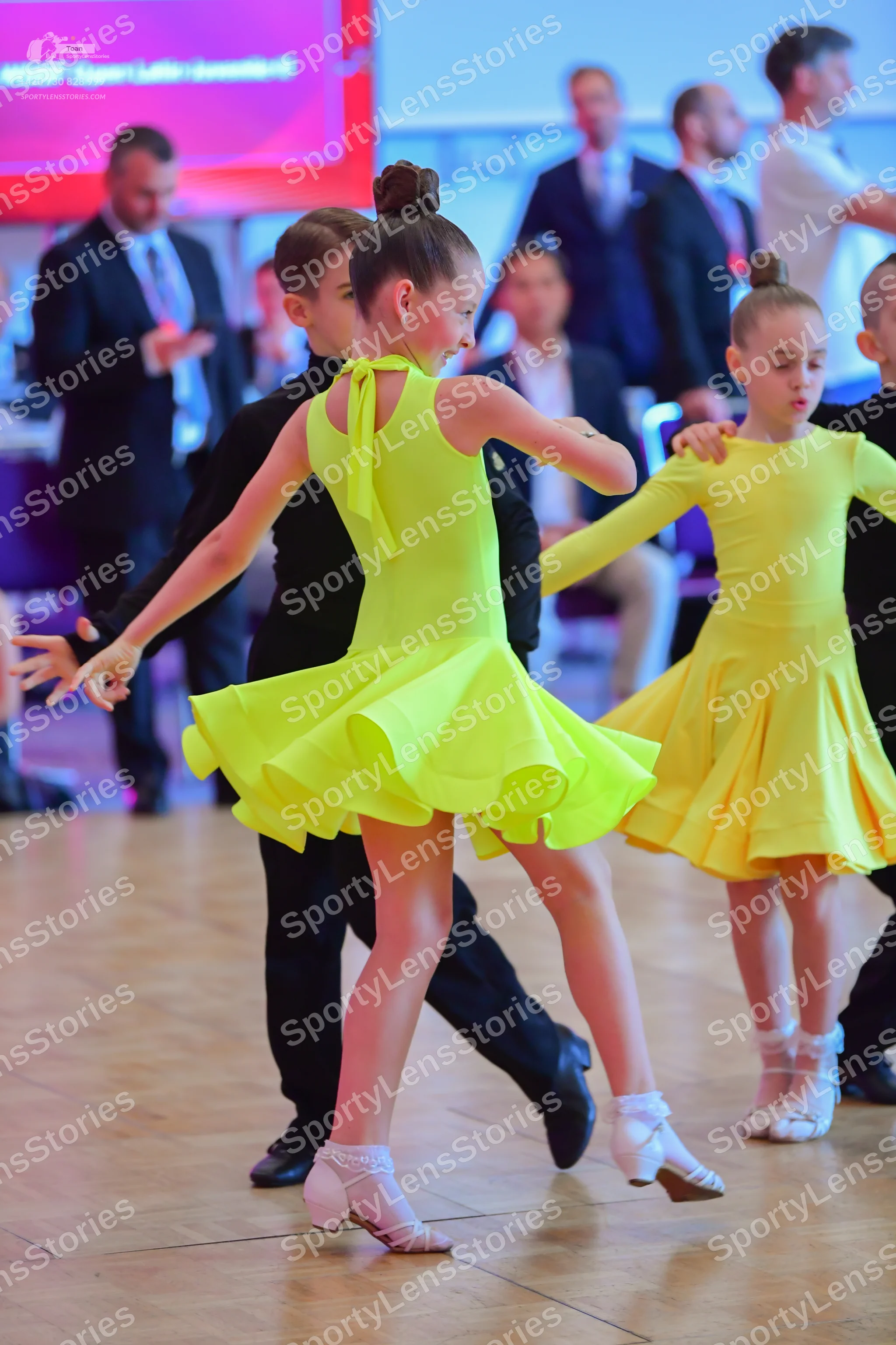Dancesport competitor: Female dancer: yellow sleeveless latin dress with a halter neck and a flared ski