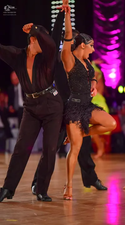 Dancesport competitor: Male dancer: black long-sleeved shirt with a deep V-neck and black trousers with