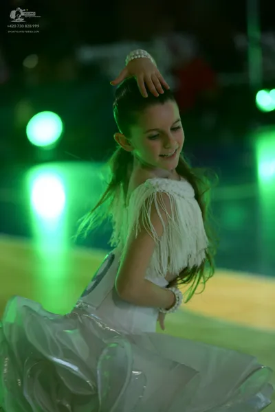 Dancesport competitor: Female dancer: white ballroom dress with a voluminous, petal-like skirt and whit