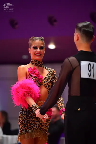 Dancesport competitor: Female dancer: leopard print latin dress with cut-outs, pink floral embellishmen