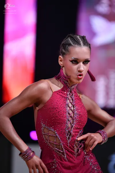 Dancesport competitor: Female dancer: magenta latin dress with heavy rhinestone/sequin embellishments, 