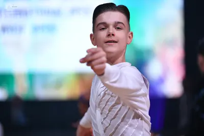 Dancesport competitor: Male dancer: white long-sleeved Latin dance shirt with textured, pleated fabric