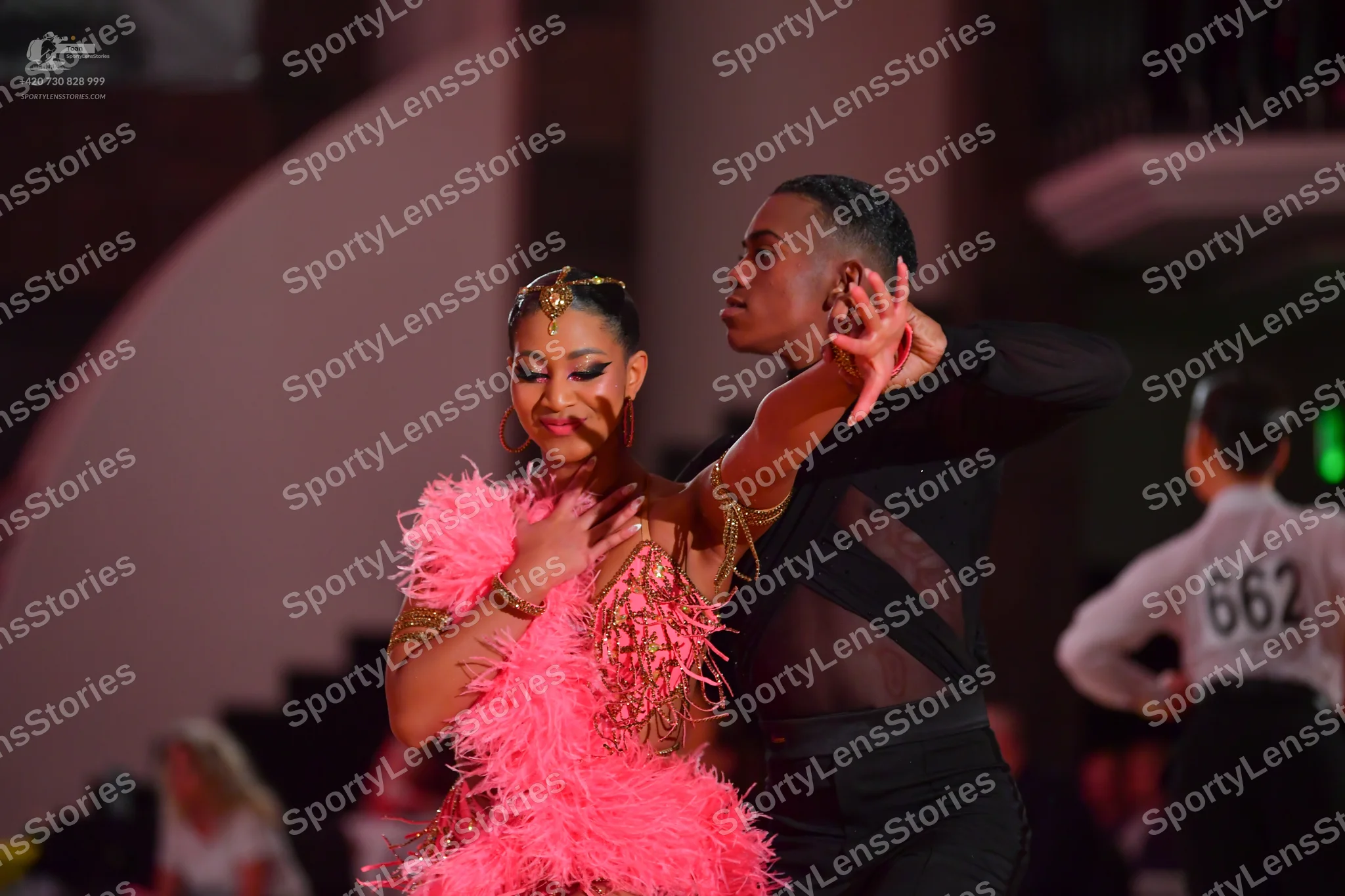 Dancesport competitor #662: Female dancer: pink Latin dress with large pink feather fringe and a nude-colore