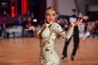 Dancesport competitor: Female dancer: white/cream Latin dance dress with long sleeves, heavy sequin/cry