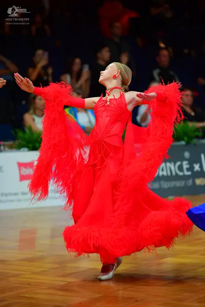 Dancesport competitor: Female dancer: red latin dress with long sleeves and large amounts of red fringe