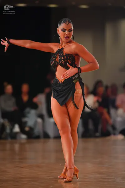 Dancesport competitor: Female dancer: black Latin dance dress with a lace/sequined bodice, cutout detai