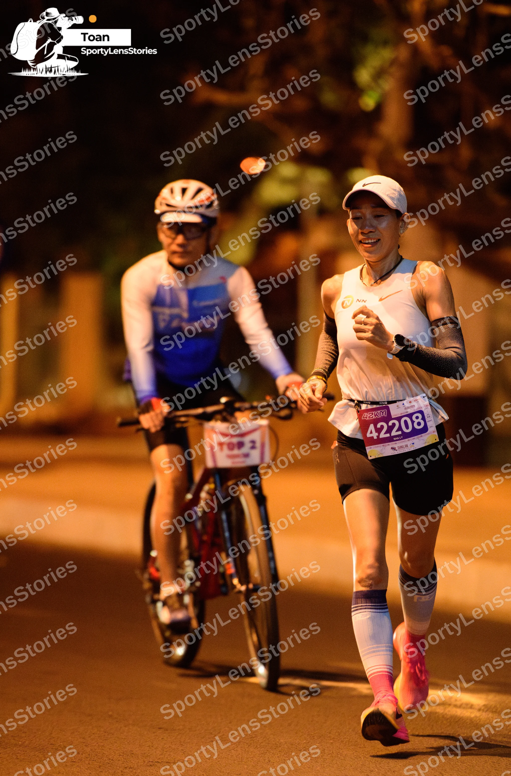 Marathon runner #42208: Runner 1: white tank top, black shorts, white cap, grey arm sleeves, white calf 