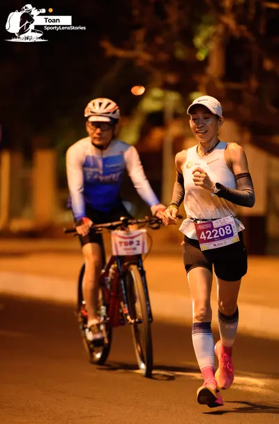 Marathon runner #42208: Runner 1: white tank top, black shorts, white cap, grey arm sleeves, white calf 