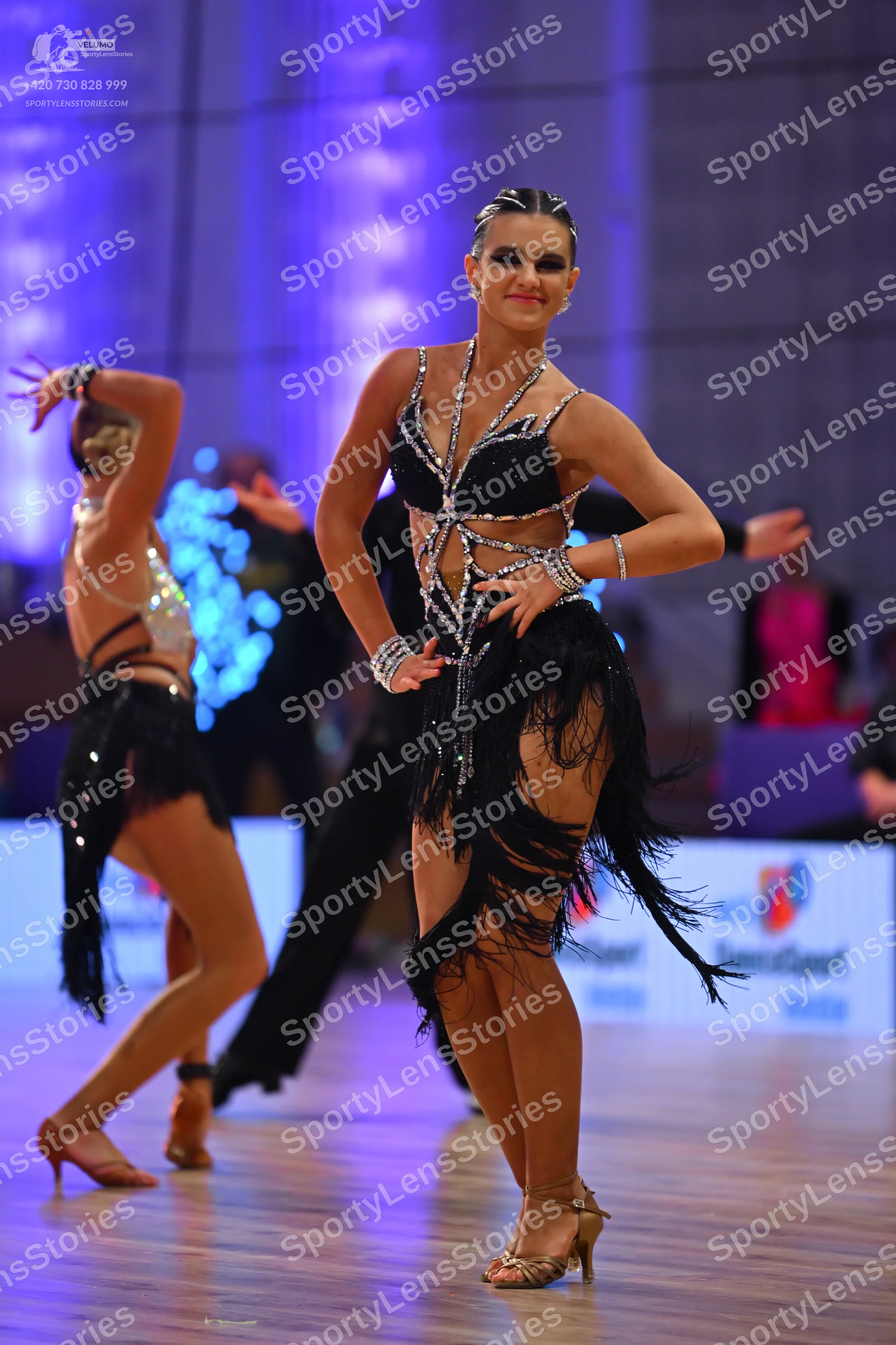 Dancesport competitor: Female dancer (center): black latin dress with silver rhinestone patterns on the