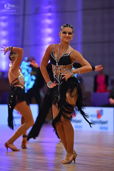 Dancesport competitor: Female dancer (center): black latin dress with silver rhinestone patterns on the