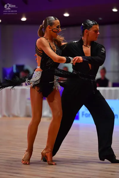 Dancesport competitor: Female dancer: black latin dress with sequins and a short, layered skirt