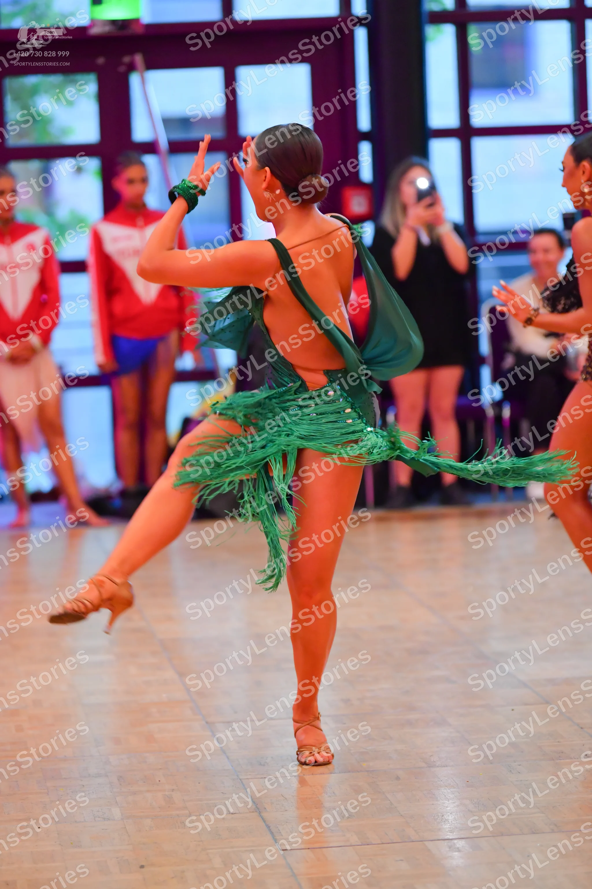 Dancesport competitor: Main dancer: green Latin dance dress with heavy green fringe on the skirt and bo