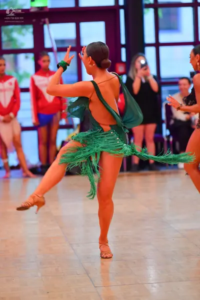 Dancesport competitor: Main dancer: green Latin dance dress with heavy green fringe on the skirt and bo