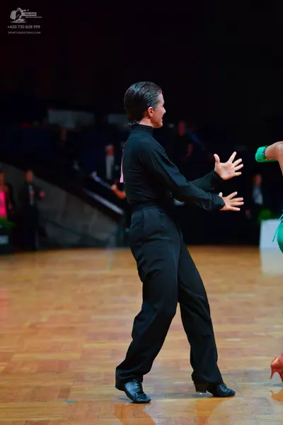 Dancesport competitor: Male dancer: black long-sleeved top and black trousers
