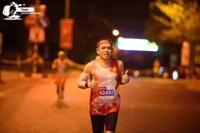 Marathon runner #42492: Runner 1: white and red patterned tank top, black shorts, headband