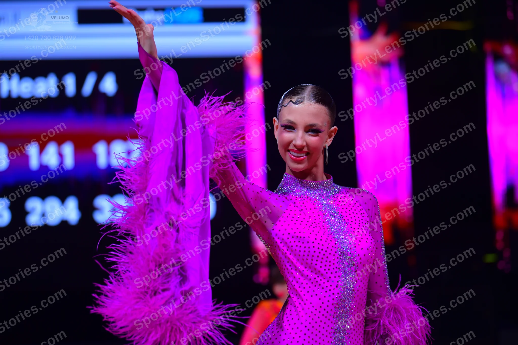 Dancesport competitor: Female dancer: pink long-sleeve latin dress with sequins and feather trim