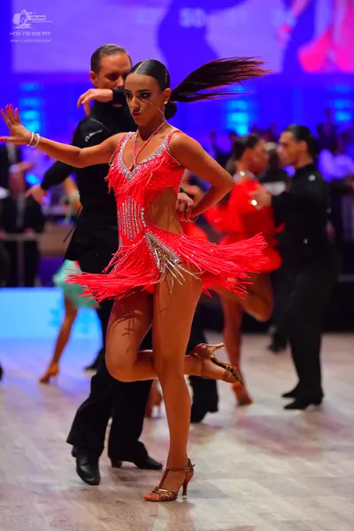 Dancesport competitor: Female dancer: red latin dress with fringe and silver sequins