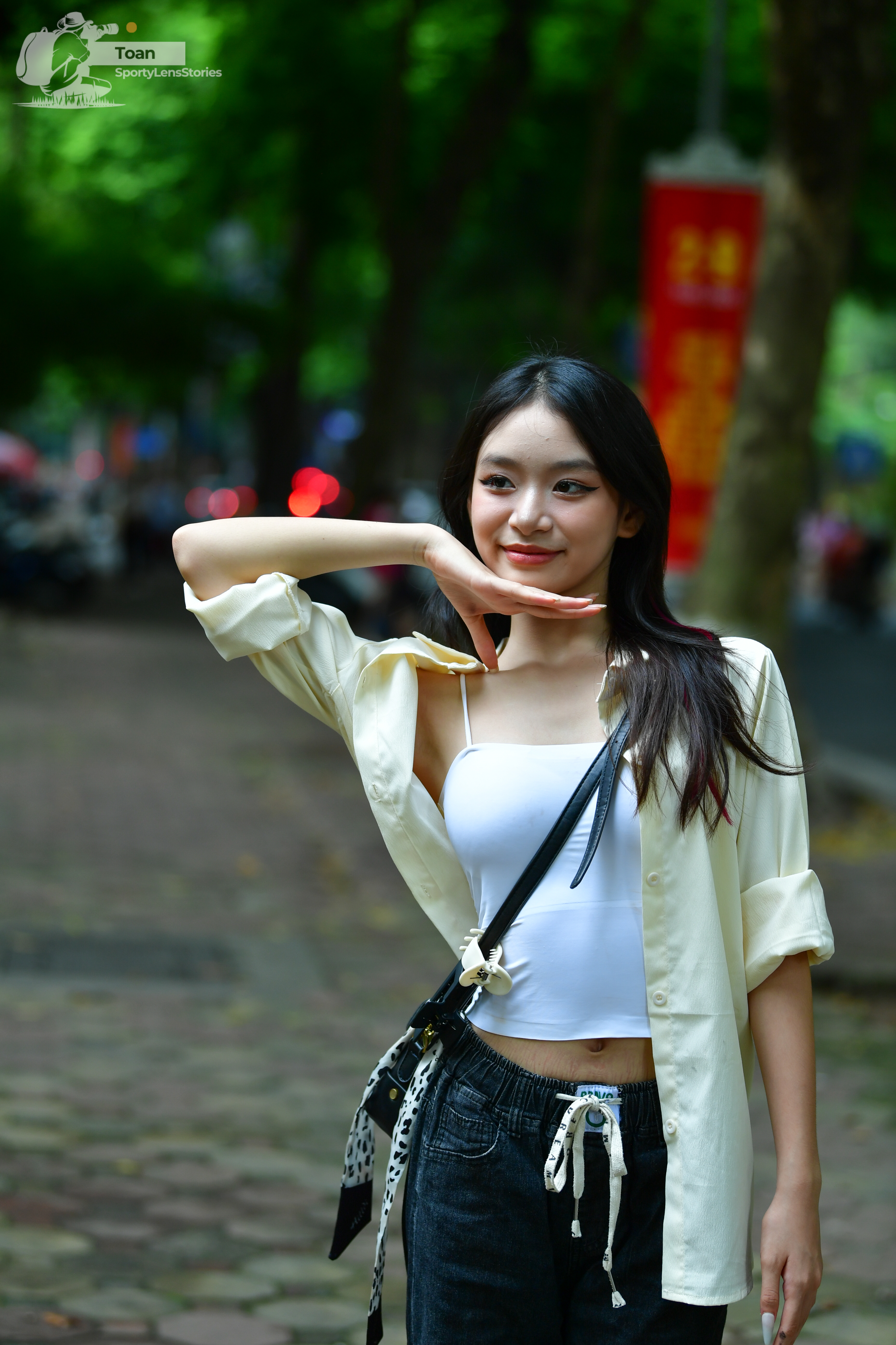 Dancesport competitor: Female dancer: white tank top, light yellow unbuttoned shirt, and black pants wi
