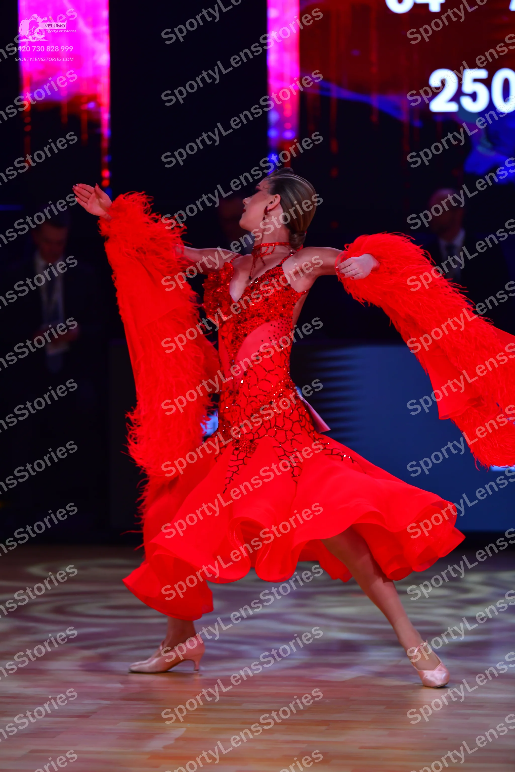 Dancesport competitor: Female dancer: red Latin dress with sequin embellishments on the bodice and larg