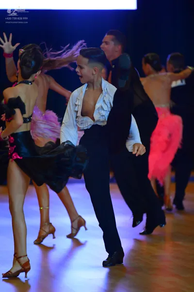 Dancesport competitor: Female dancer (left): black latin dress with pink sequin accents