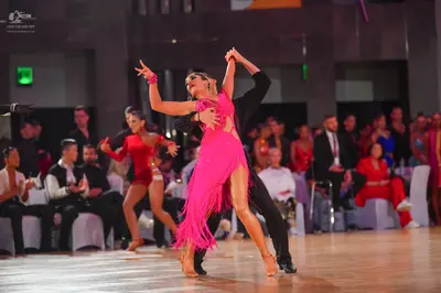Dancesport competitor: Main female dancer: pink Latin dance dress with long fringe