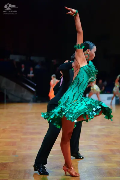 Dancesport competitor: Female dancer: emerald green Latin dress with large green sequins (paillettes) c
