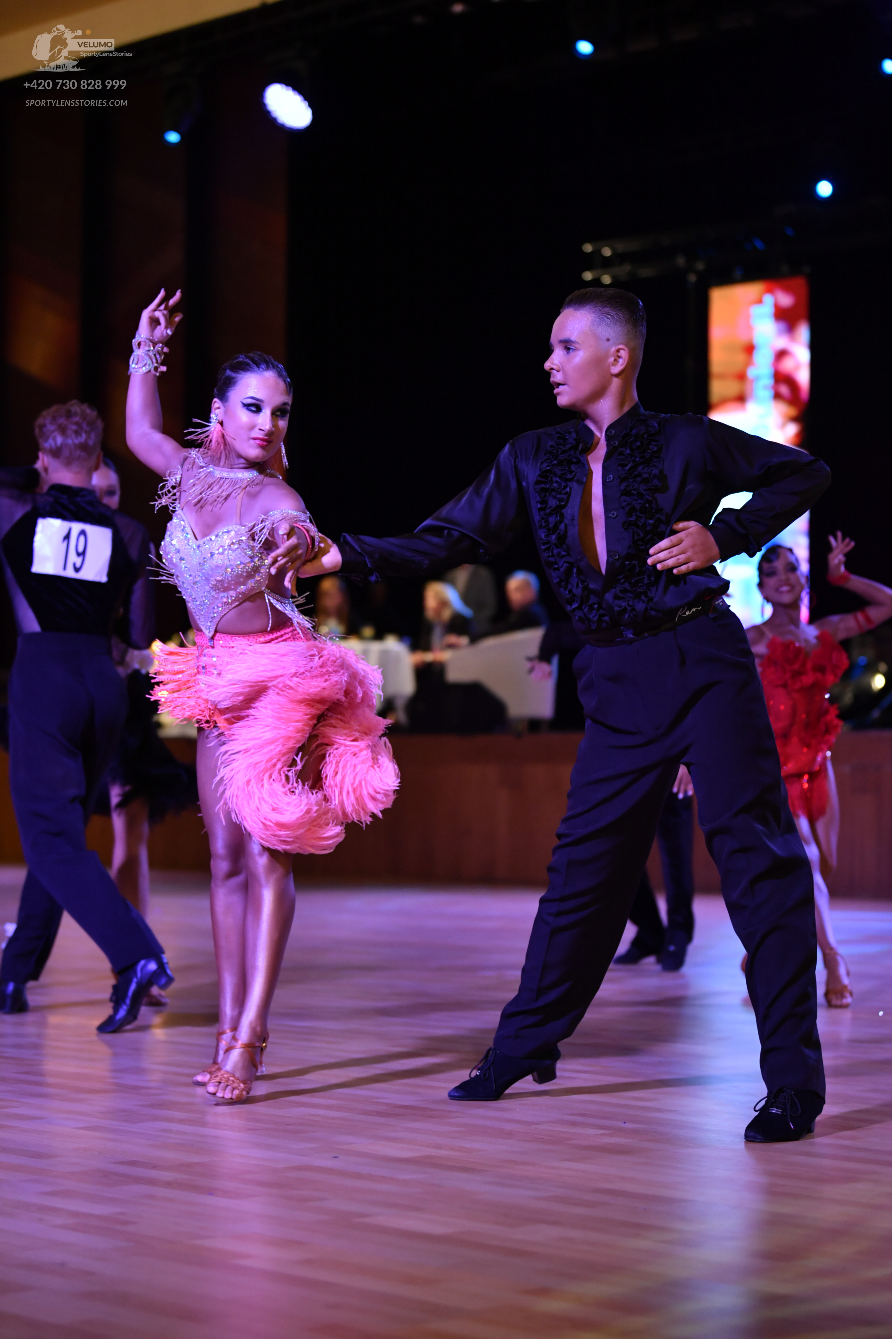 Dancesport competitor #19: ** Black tailsuit
*   **Fabric:** Primarily satin with sequin lapels
*   **Style