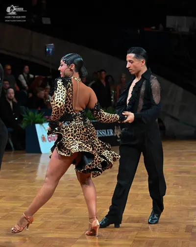 Dancesport competitor: Female dancer: leopard print latin dress with a flared skirt, large hoop earring