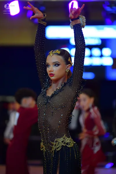 Dancesport competitor: Main female dancer: nude-colored, long-sleeved, sheer dress heavily embellished 