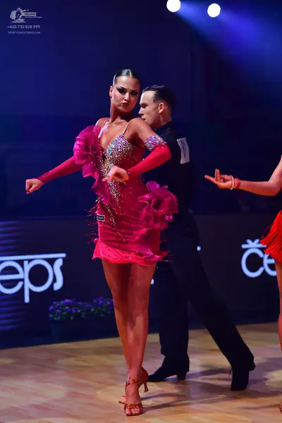 Dancesport competitor: Main female dancer: pink Latin dress with sequins and ruffles