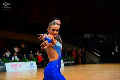 Dancesport competitor: Female dancer: blue sequined Latin dress with side cutouts