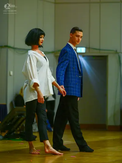 Dancesport competitor: Female dancer: white oversized button-down shirt and black cropped trousers