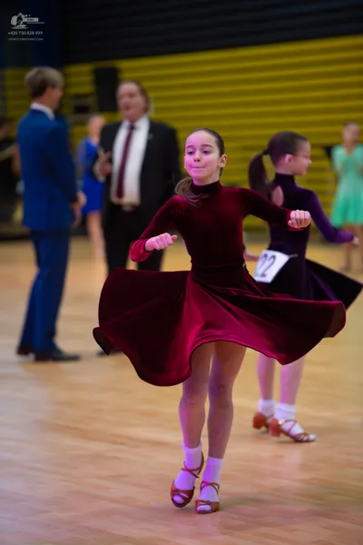 Dancesport competitor: ** Red Latin Dress
*   **Color:** Bright Red
*   **Fabric:** Likely Satin (appea
