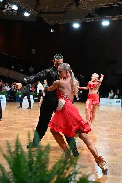 Dancesport competitor: Male dancer: black long-sleeved top with a textured pattern and black trousers