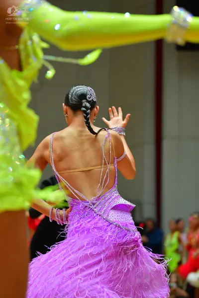 Dancesport competitor: Female dancer in center: lavender latin dress with long fringe and sequin-embell