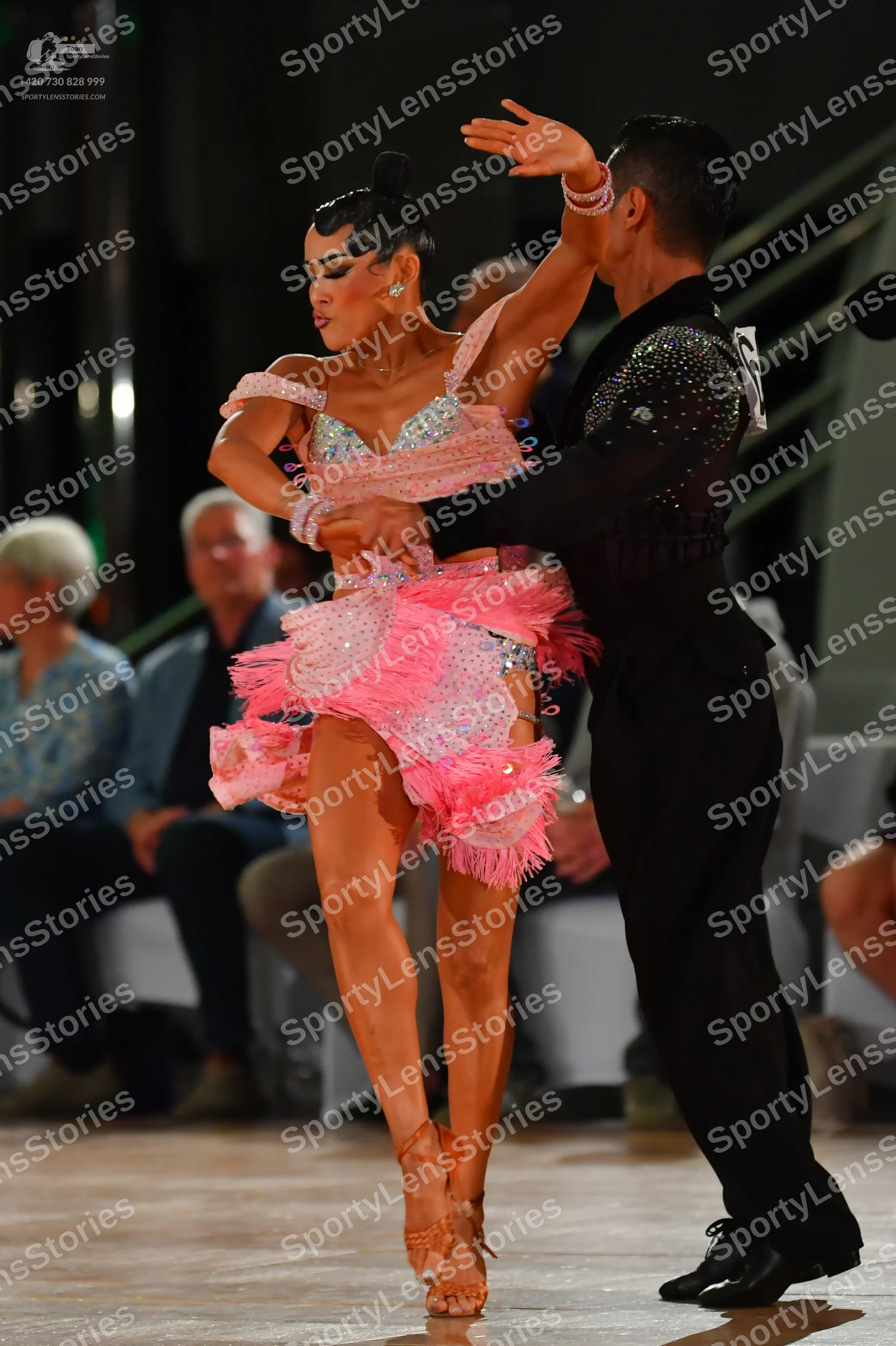 Dancesport competitor: Male dancer: black suit with silver/white sequin embellishments on the shoulder/