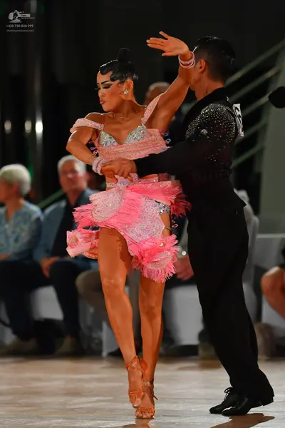 Dancesport competitor: Male dancer: black suit with silver/white sequin embellishments on the shoulder/