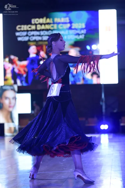 Dancesport competitor #61: Female dancer: Navy blue ballroom dress with long sheer sleeves, an open back, a