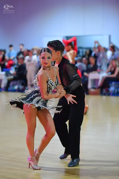 Dancesport competitor: Female dancer: black and silver latin dance dress with sequin patterns and silve