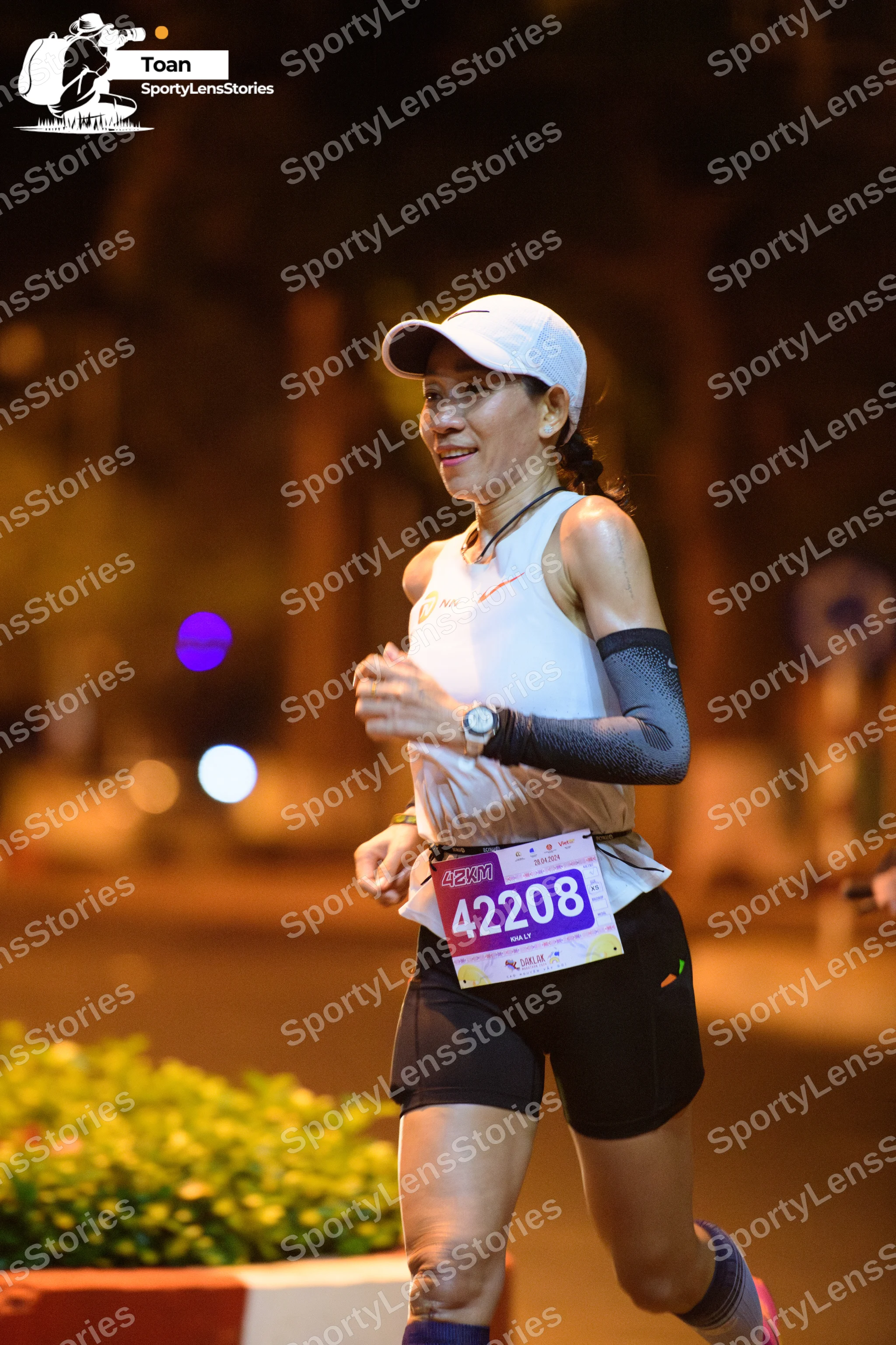 Marathon runner #42208: Runner 1: white tank top, black shorts, white cap, grey arm sleeve, watch