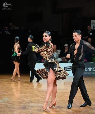 Dancesport competitor: Foreground female dancer: leopard print latin dress with black sequin trim and n