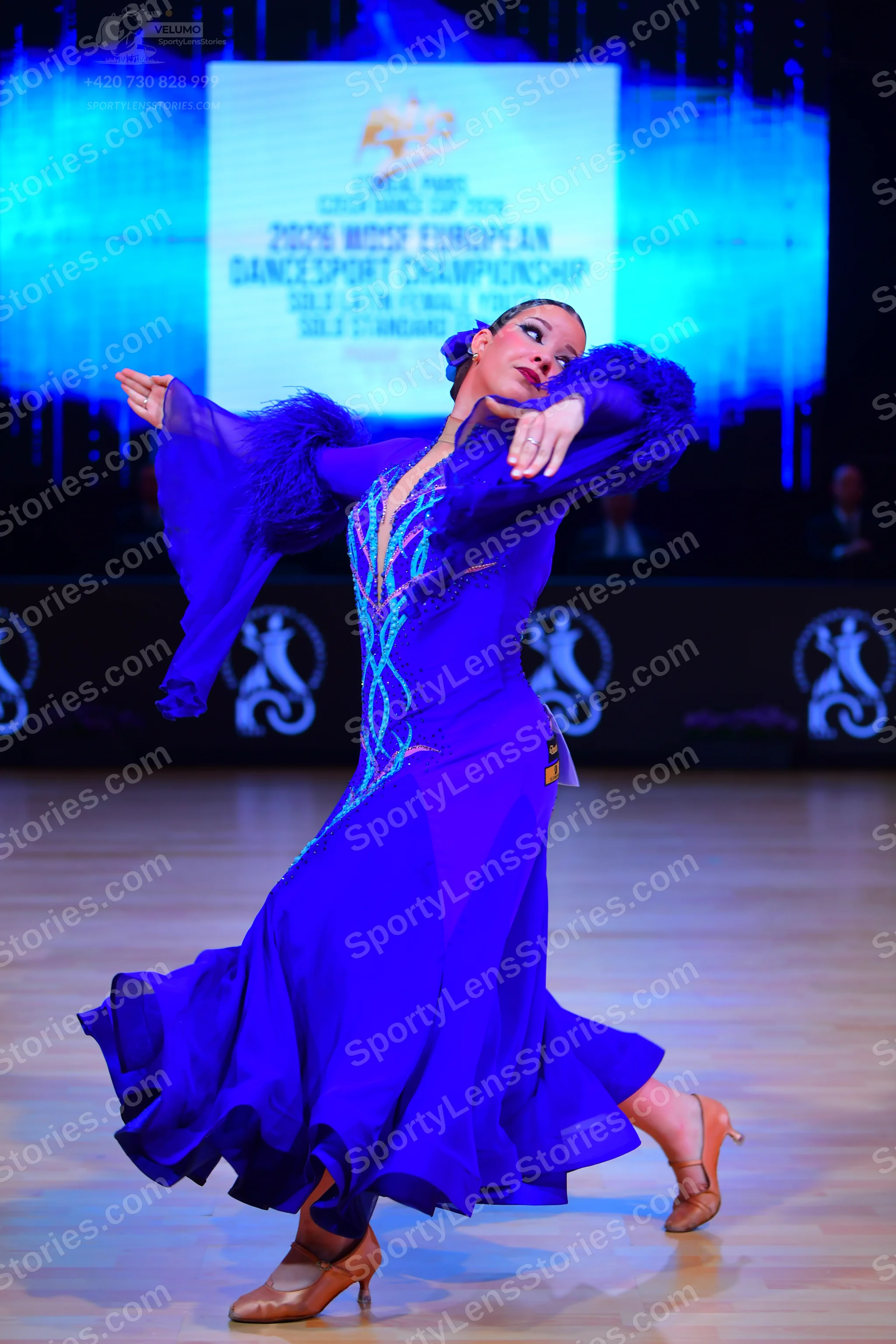 Dancesport competitor: Female dancer: deep blue latin dress with teal sequin/beaded embellishments on t