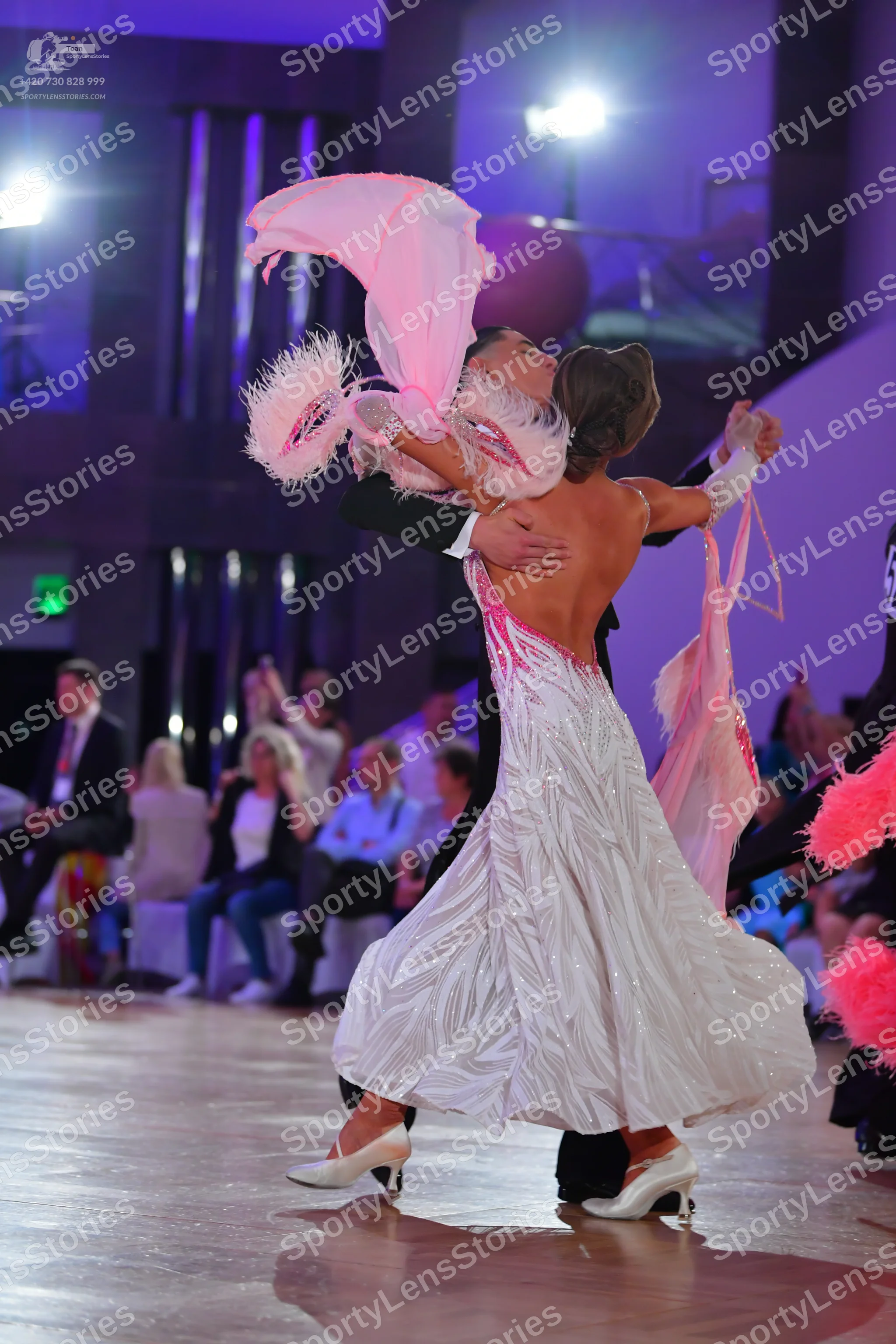 Dancesport competitor: Female dancer: white and pink flowing ballgown with swirling patterns and pink f