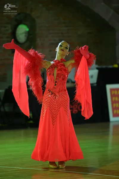 Dancesport competitor: Female dancer: red ballroom dress with a sequined chevron pattern, featuring fea