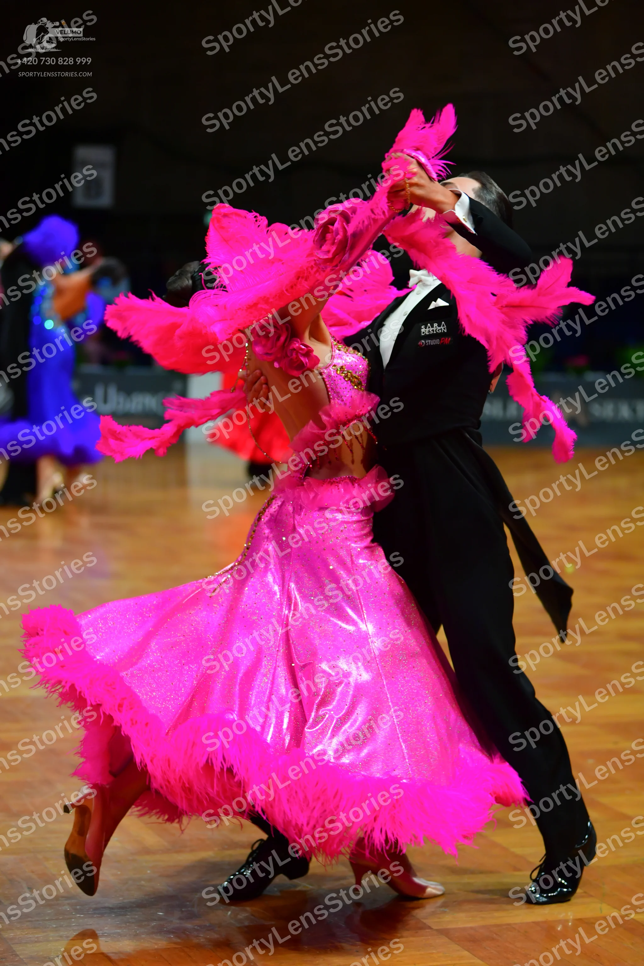 Dancesport competitor: Female dancer: bright pink ballroom dress with a voluminous skirt, shiny fabric,