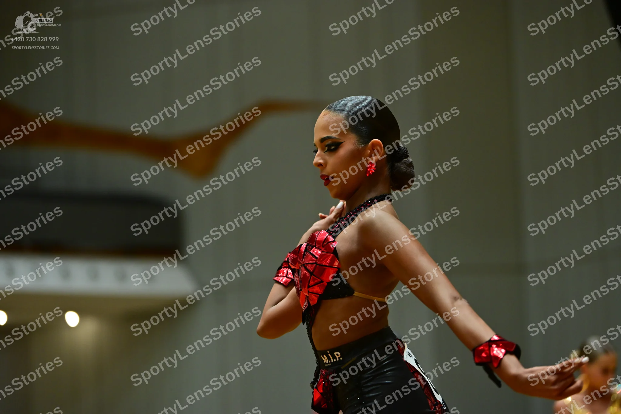 Dancesport competitor: Female dancer: black and red Latin dance costume featuring a sequined red patter