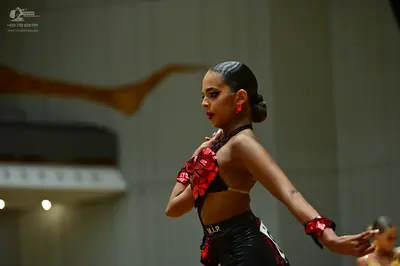 Dancesport competitor: Female dancer: black and red Latin dance costume featuring a sequined red patter