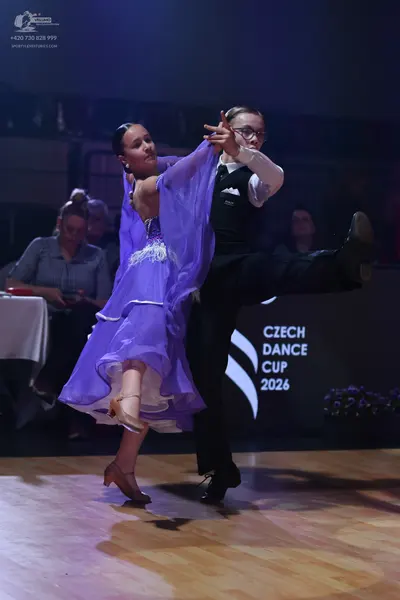 Dancesport competitor: Female dancer: purple ballroom dress with a sheer, flowing skirt and sleeves, an
