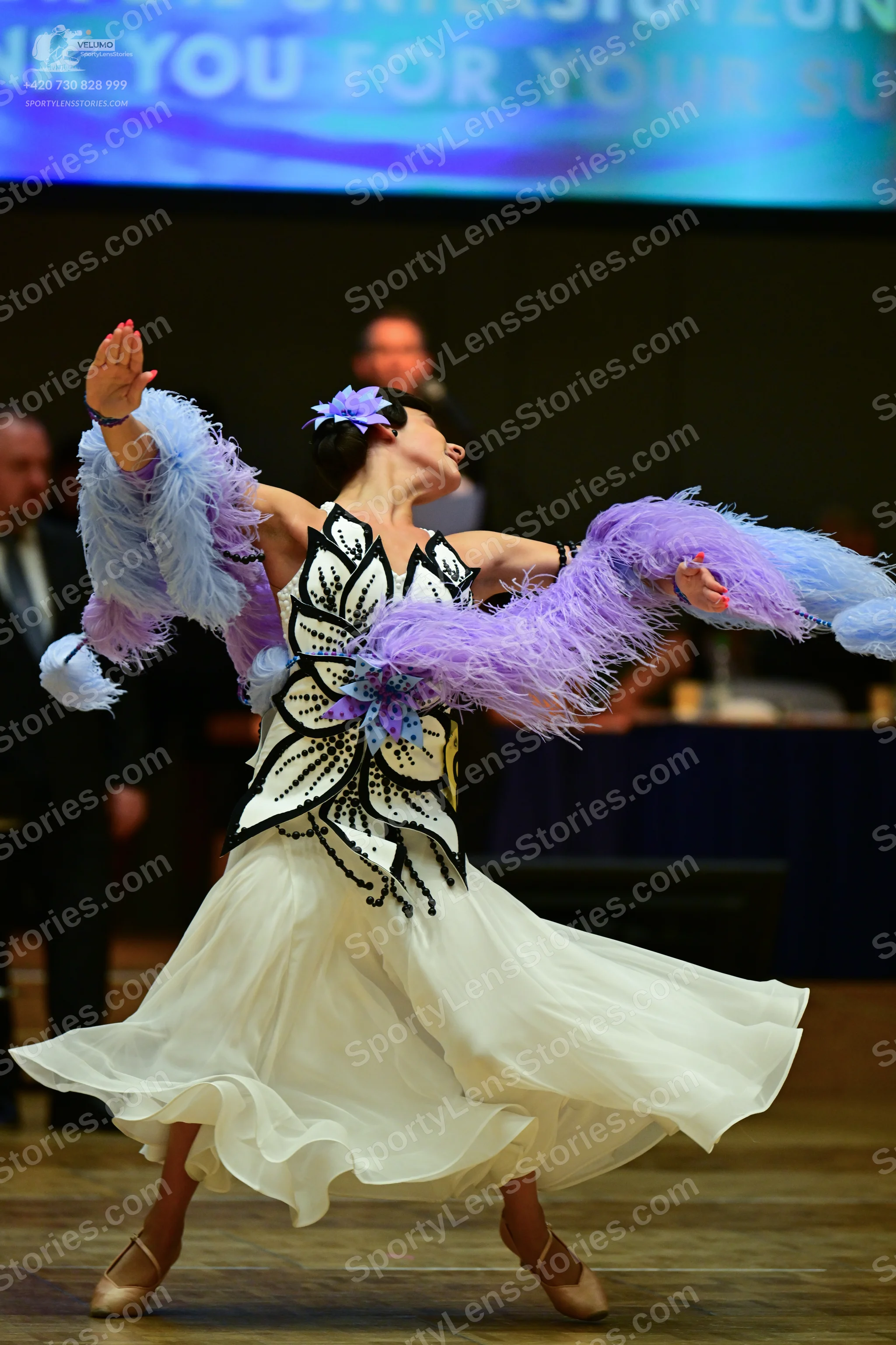 Dancesport competitor: ** White latin dress with a black flower-shaped, heavily embellished bodice