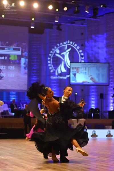 Dancesport competitor: Female dancer: black ballgown with a sequined bodice and large, voluminous black